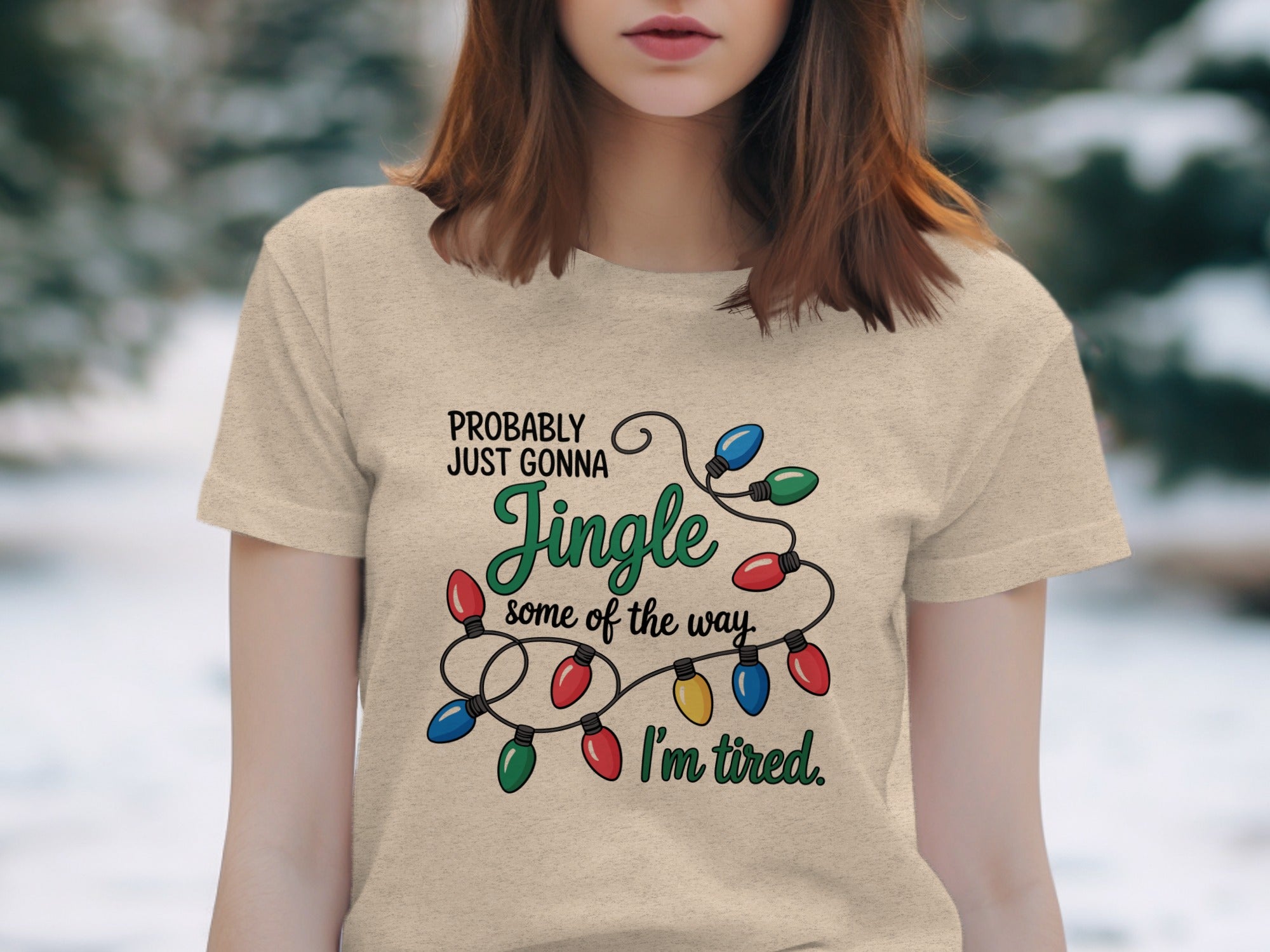 Light beige t-shirt with Christmas lights graphic and text.