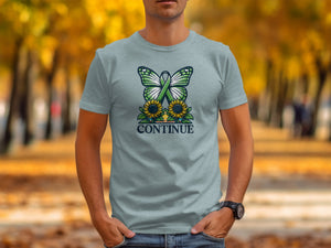 Light blue t-shirt with a graphic of a green butterfly, sunflowers, and the word "CONTINUE".