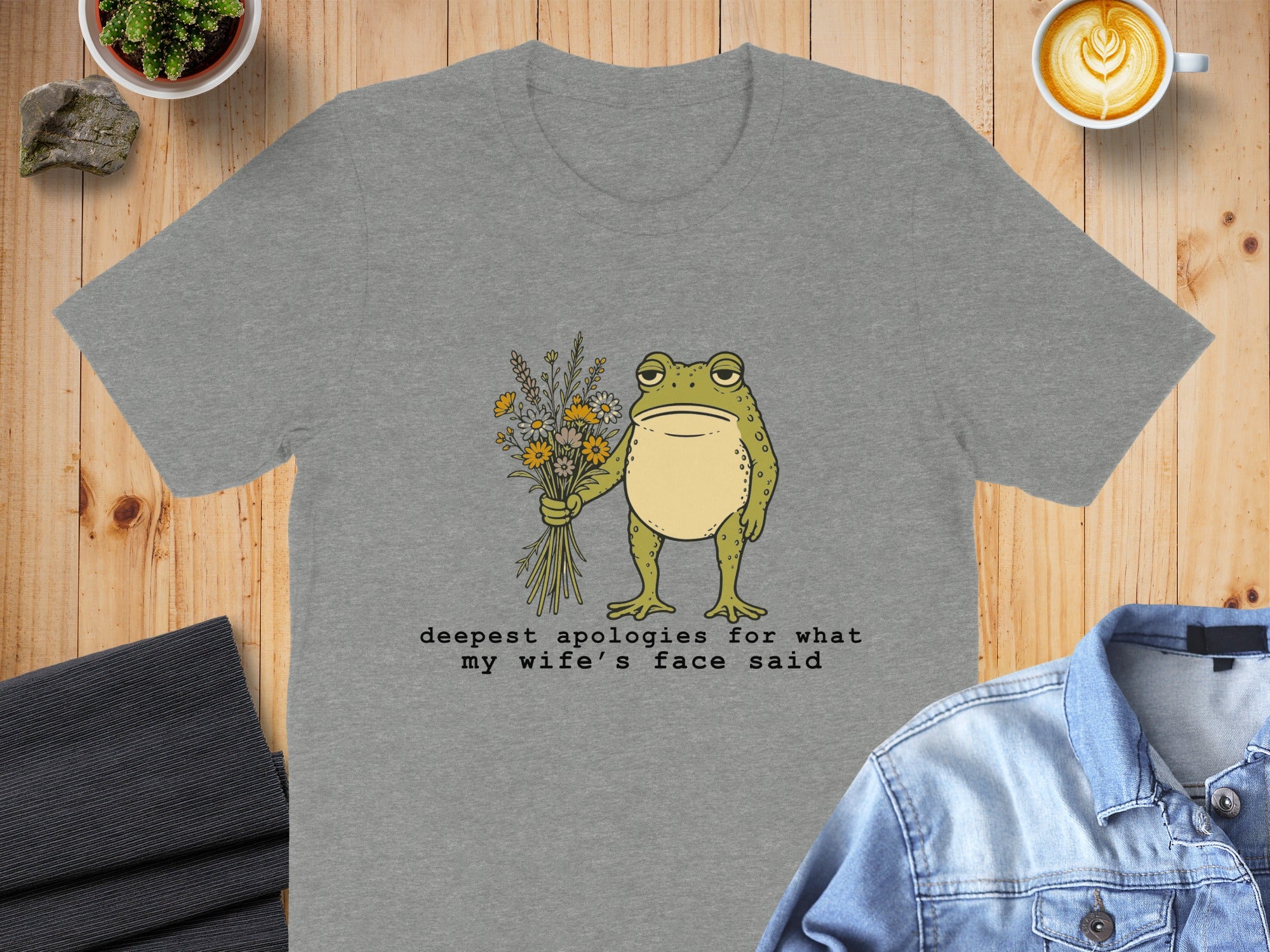 Grey t-shirt with a frog holding flowers and text.