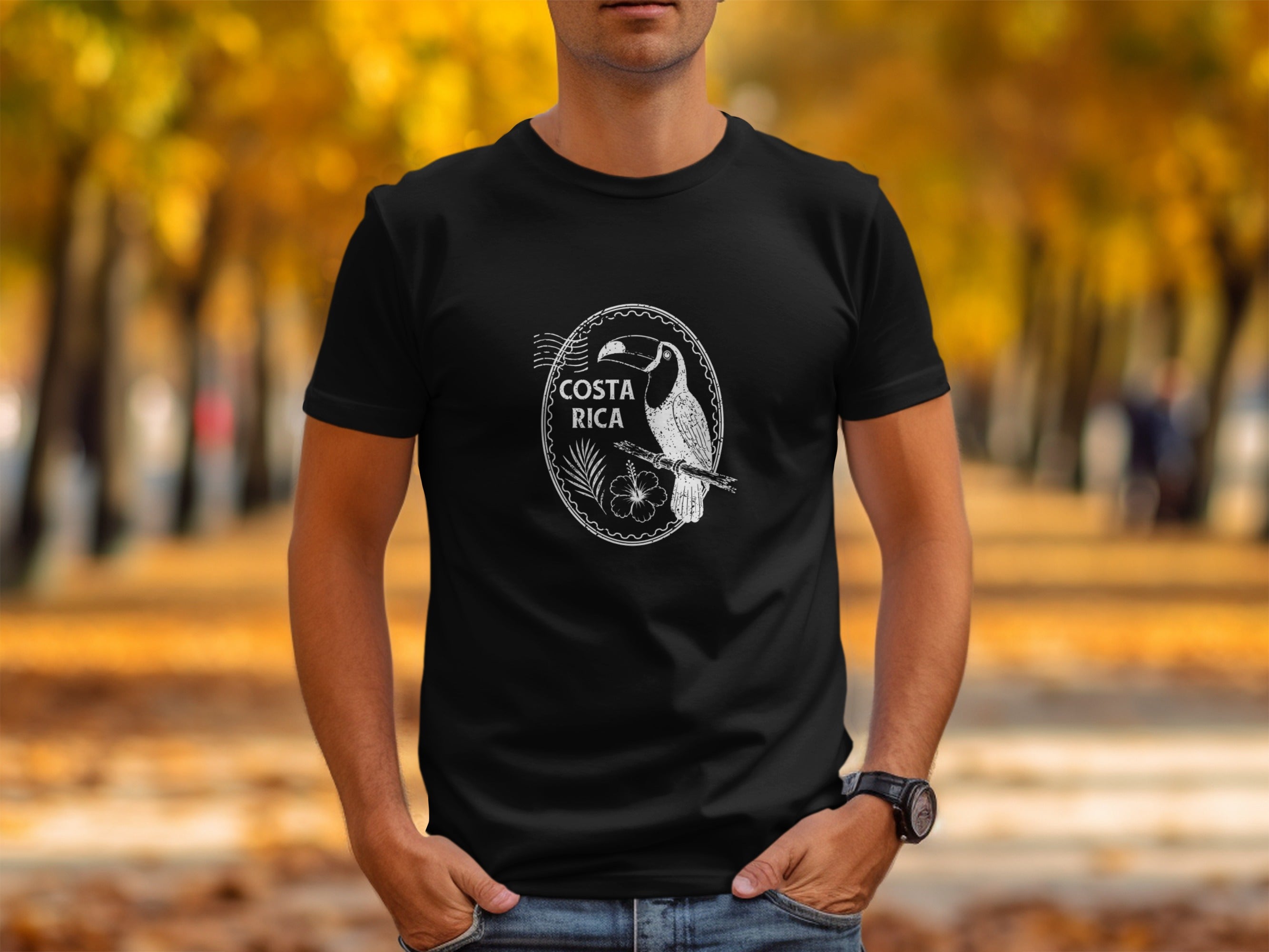 Black t-shirt with white oval graphic featuring a toucan, flower, and "COSTA RICA" text.