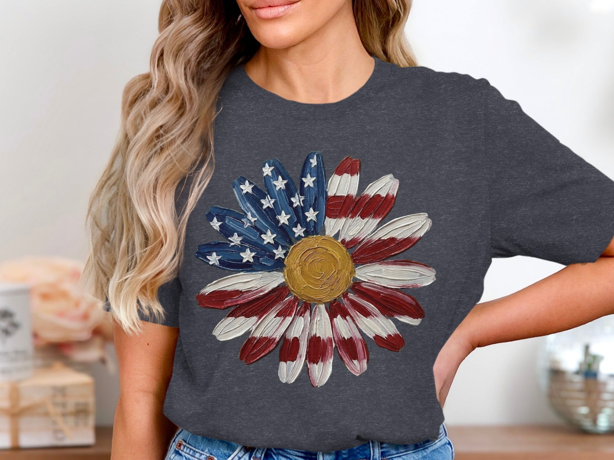 Dark gray t-shirt with a painted daisy featuring US flag petals and a gold center.