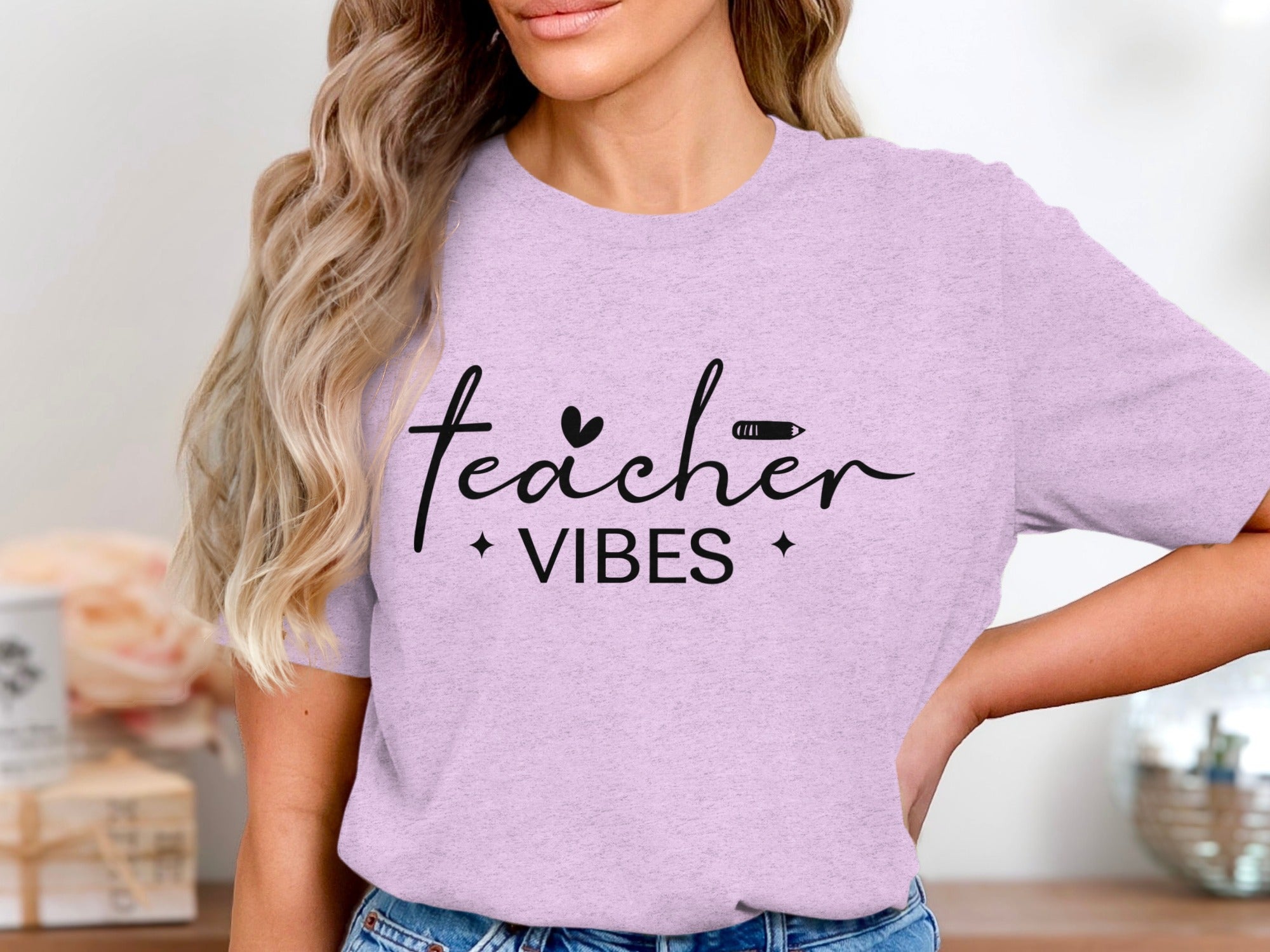 Lilac t-shirt with black text "Teacher Vibes" and heart and pencil graphics.