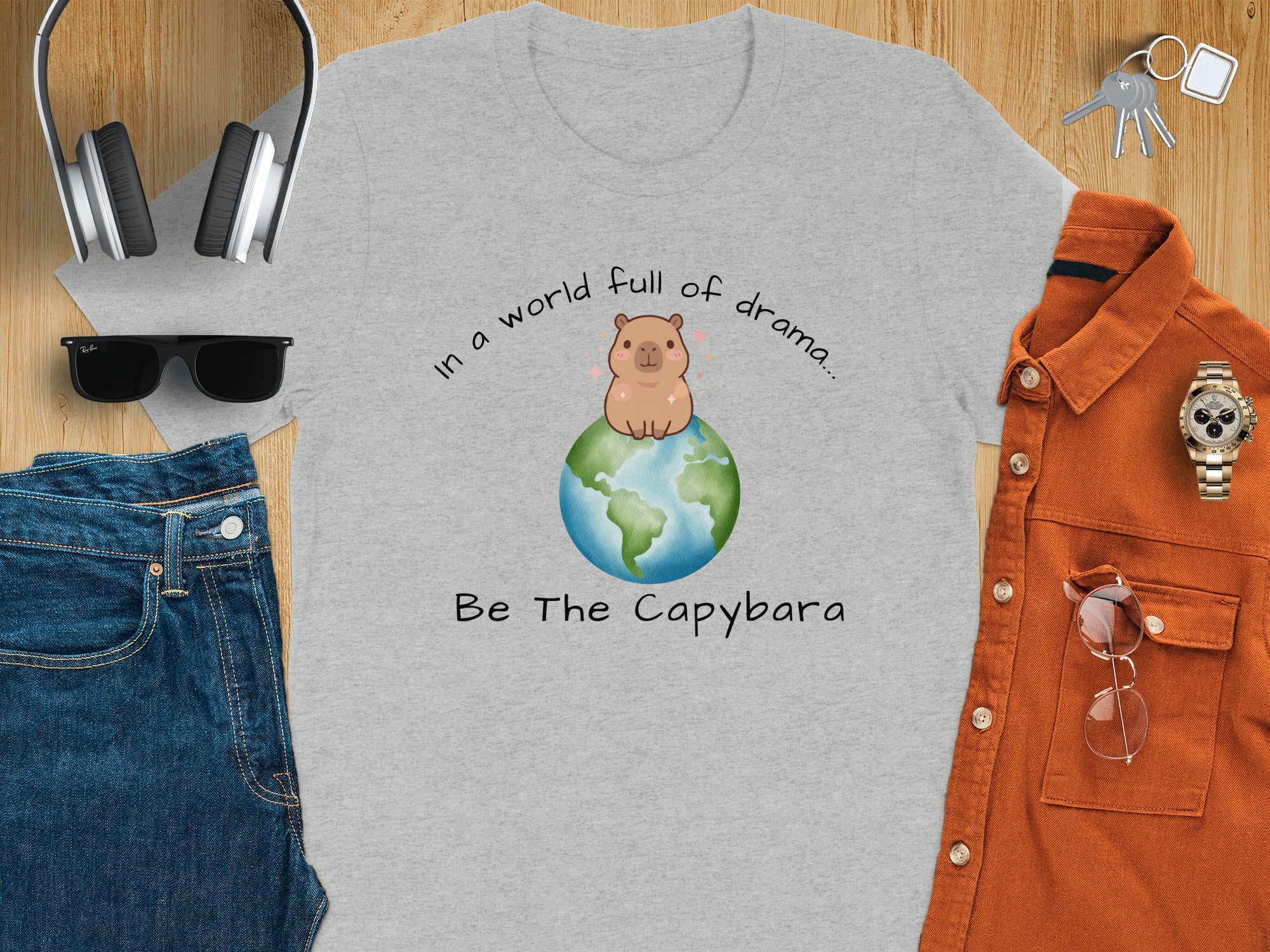 Grey t-shirt with a capybara on Earth and text "Be The Capybara".