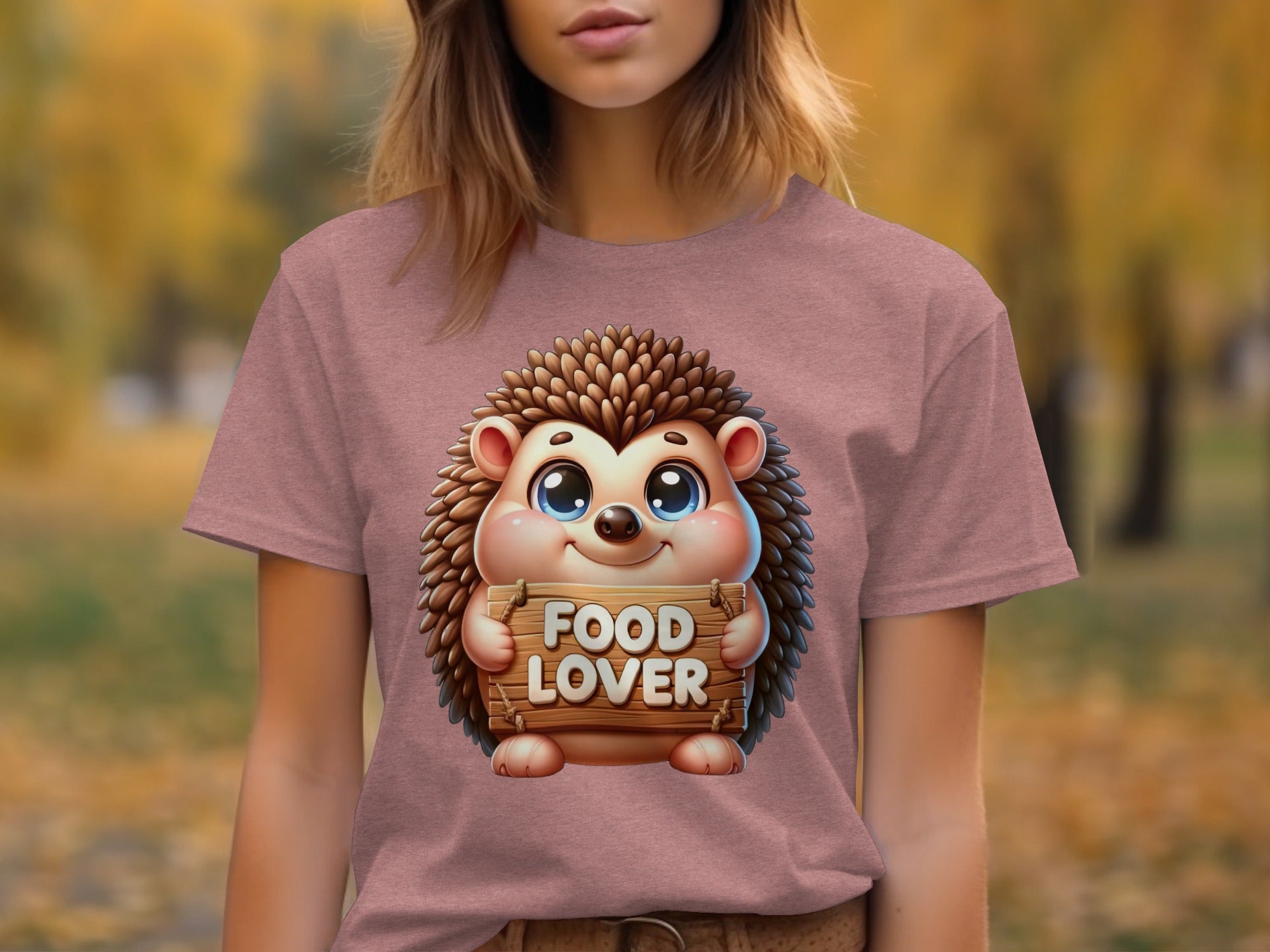 Illustration of a cartoon hedgehog holding a "FOOD LOVER" sign on a pink t-shirt.