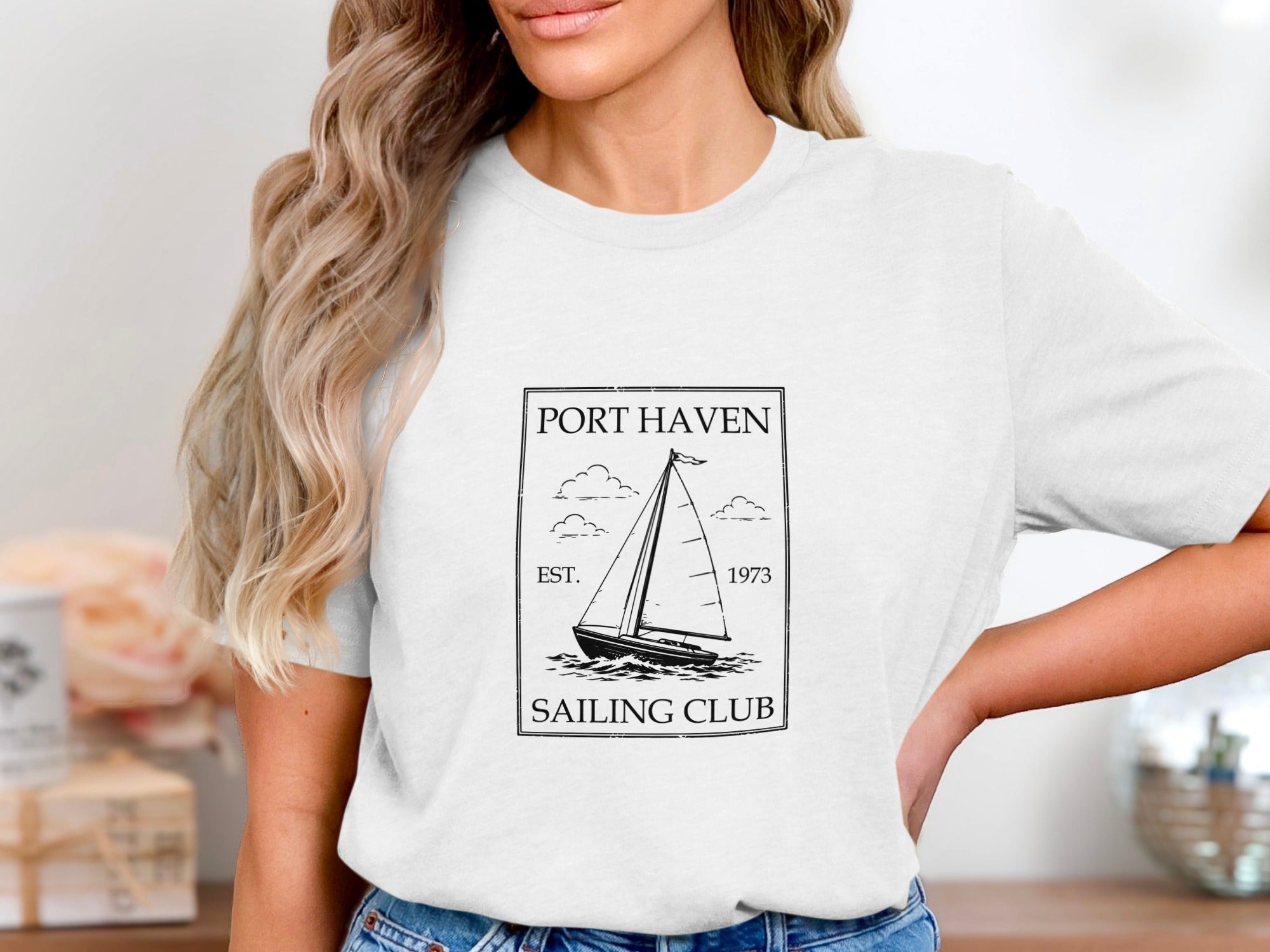 White t-shirt with black graphic: Port Haven Sailing Club est. 1973 sailboat design.