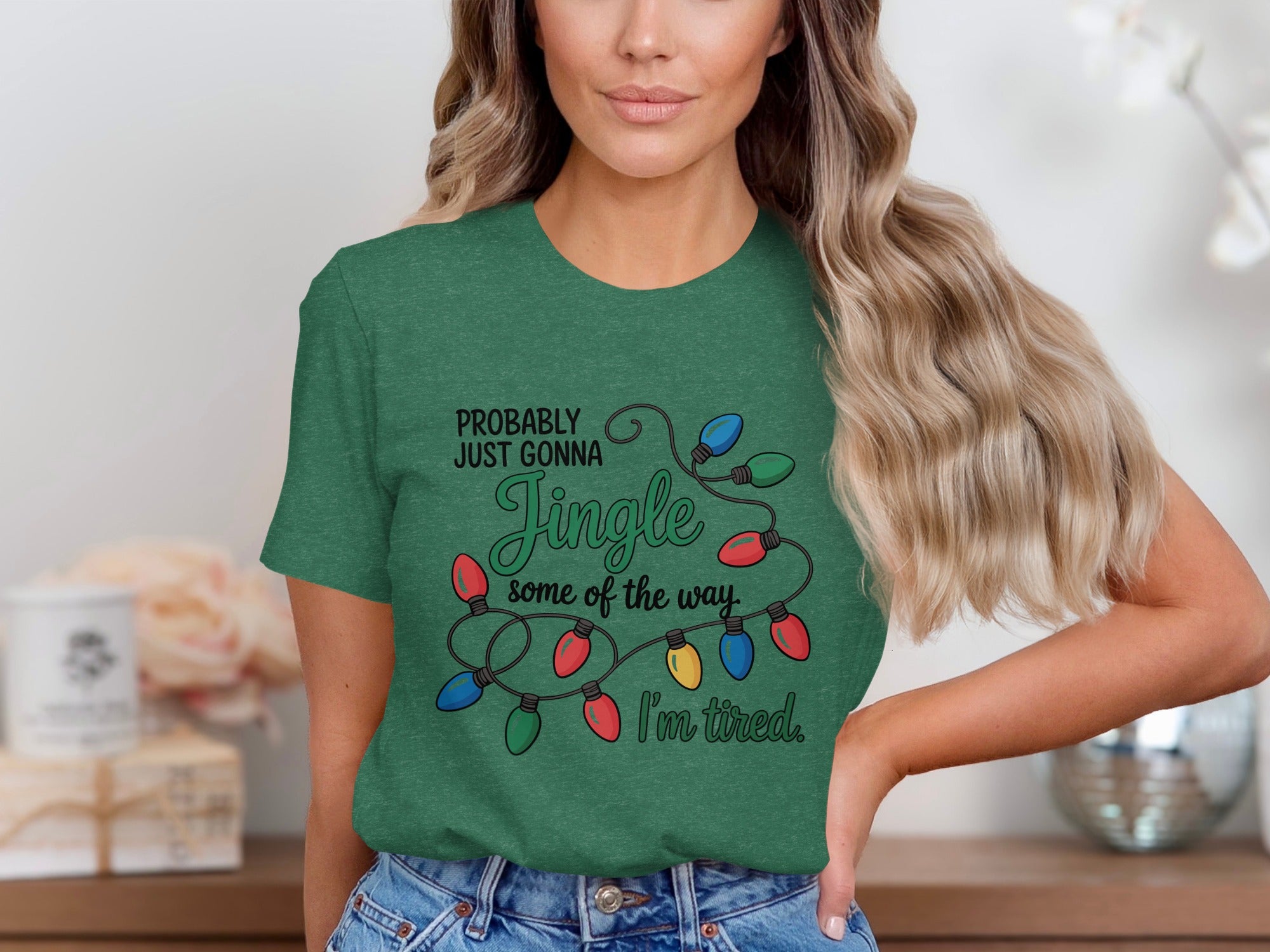 Green t-shirt with Christmas lights graphic and text: "PROBABLY JUST GONNA Jingle some of the way. I'm tired."