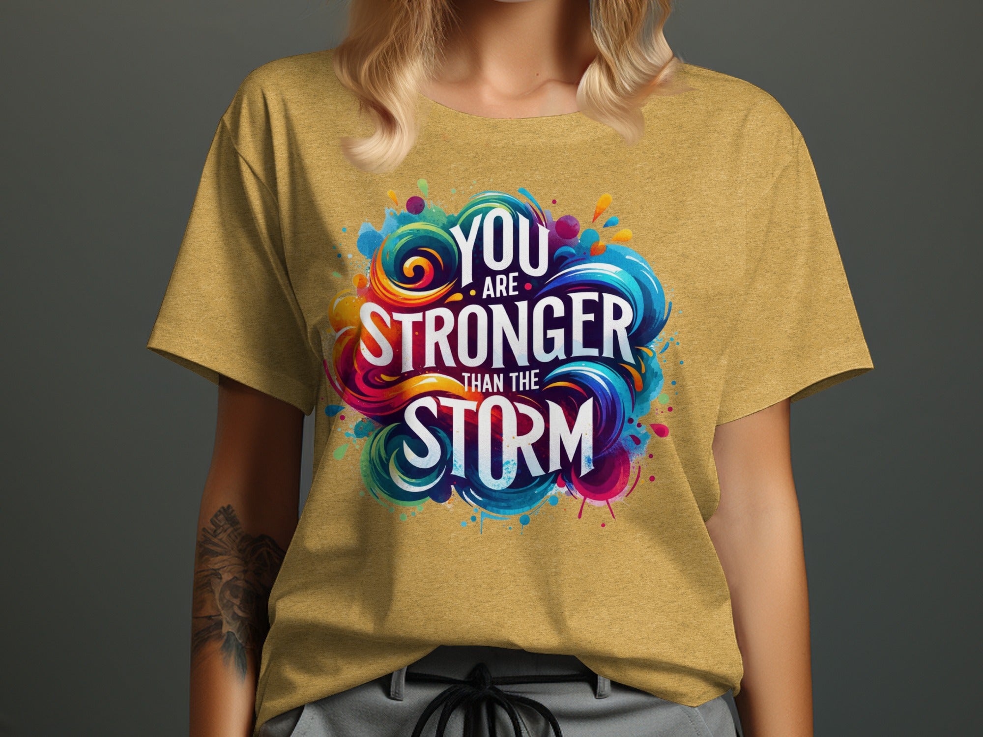 Yellow t-shirt with colorful "You are stronger than the storm" graphic.