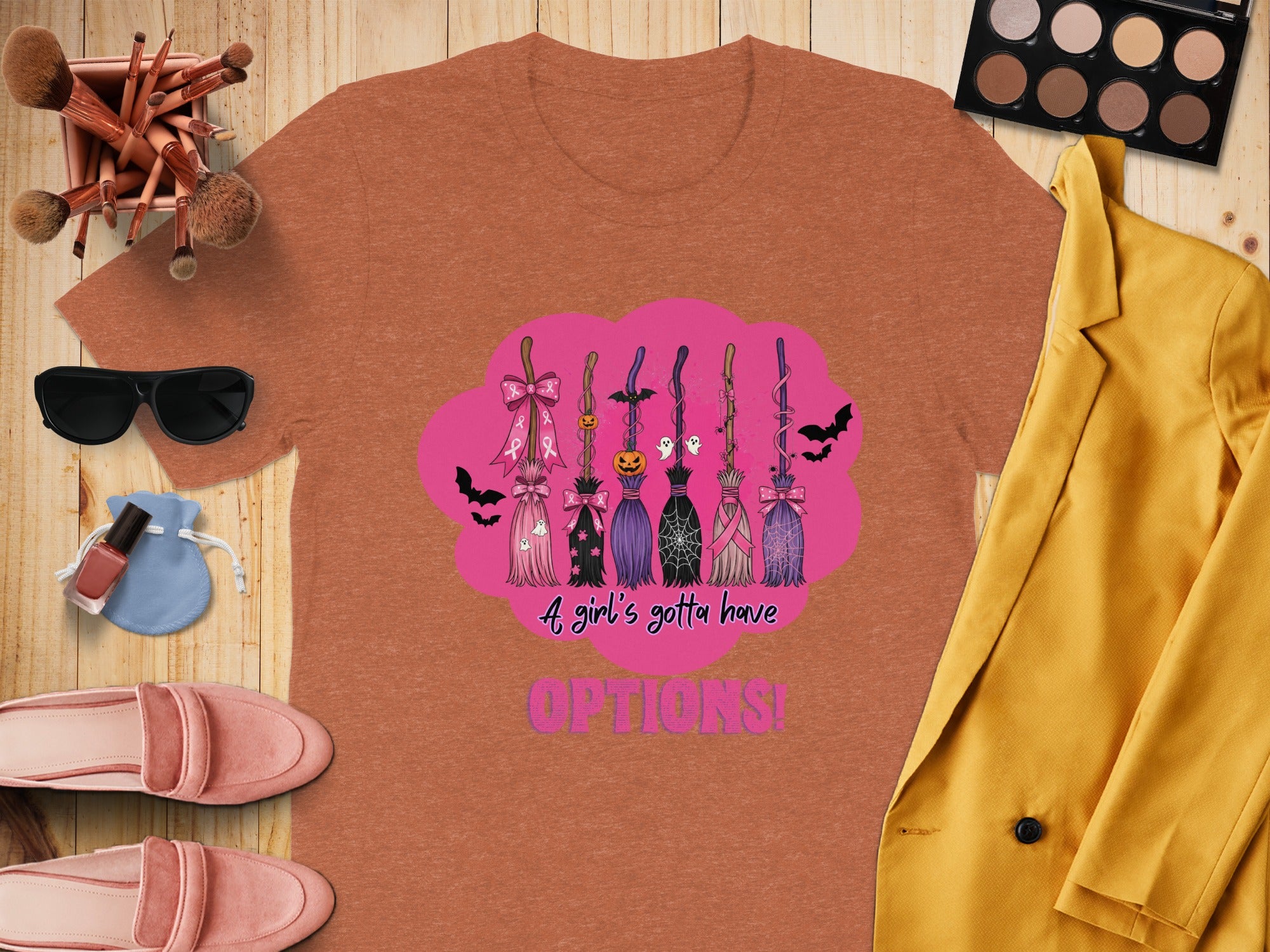 Orange t-shirt with brooms, bats, ghosts, and text "A girl's gotta have OPTIONS!".