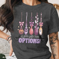 Dark gray t-shirt with a Halloween-themed graphic of brooms, ghosts, and the text "A girl's gotta have OPTIONS!".