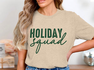 Light beige t-shirt with green text that reads "HOLIDAY squad."