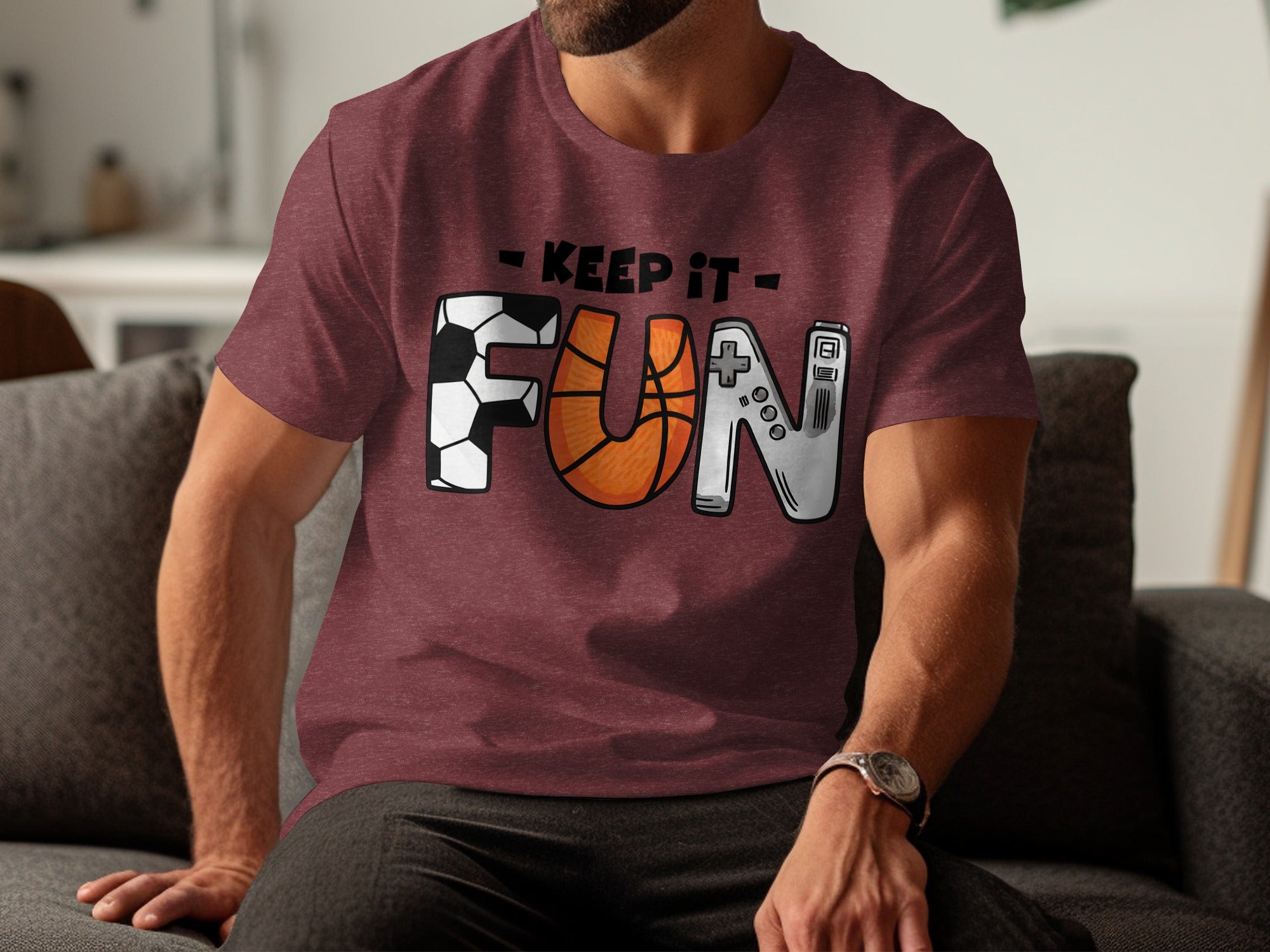 Maroon t-shirt with "KEEP IT FUN" text featuring soccer, basketball, and game controller graphics.