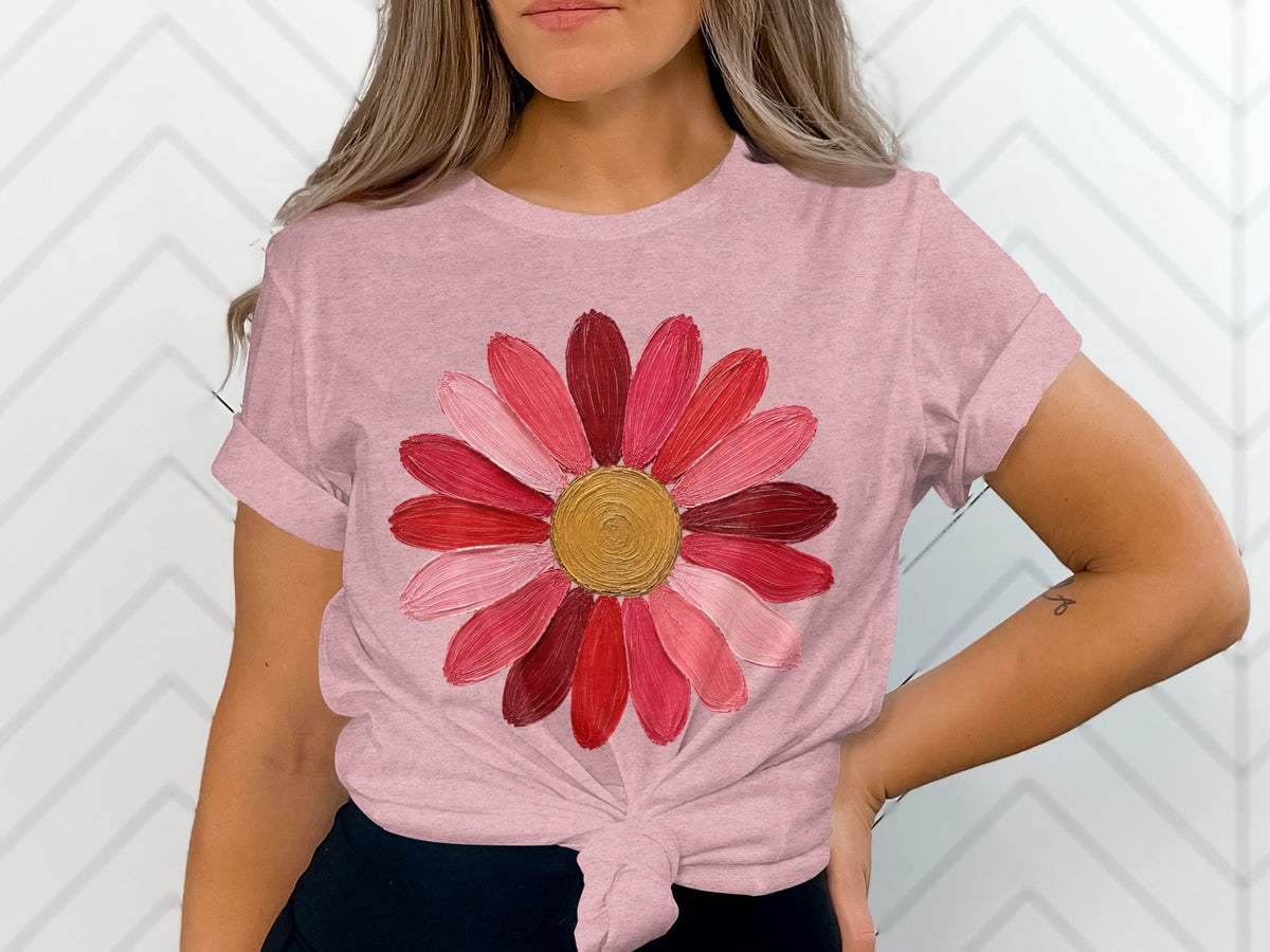 Pink t-shirt with a textured, multi-colored flower graphic.