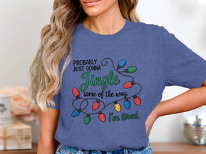 Blue t-shirt with string lights graphic and text: "PROBABLY JUST GONNA Jingle some of the way. I'm tired."