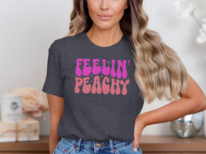 Dark gray t-shirt with pink and light pink "Feelin' Peachy" text.