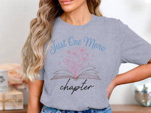 Grey t-shirt with "Just One More chapter" and an open book with flowers graphic.