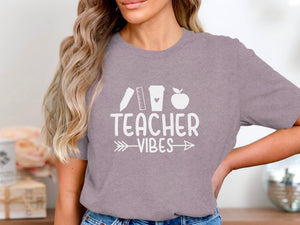 Gray t-shirt with white text "TEACHER VIBES" and school icons.