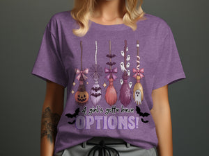Purple t-shirt with Halloween brooms, ghosts, bats, and text "A girl's gotta have OPTIONS!"