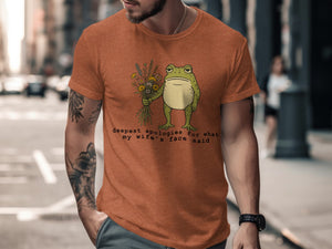 Orange t-shirt with a sad frog holding flowers and text about wife's face.