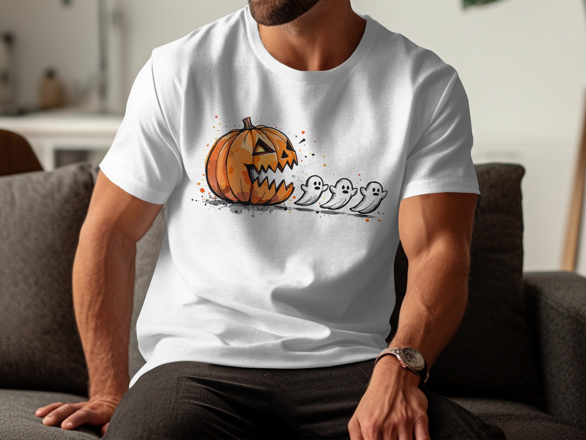 White t-shirt with a graphic of a jack-o'-lantern chasing three ghosts.