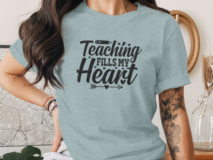 Light blue t-shirt with "Teaching Fills My Heart" text and pencil graphic.