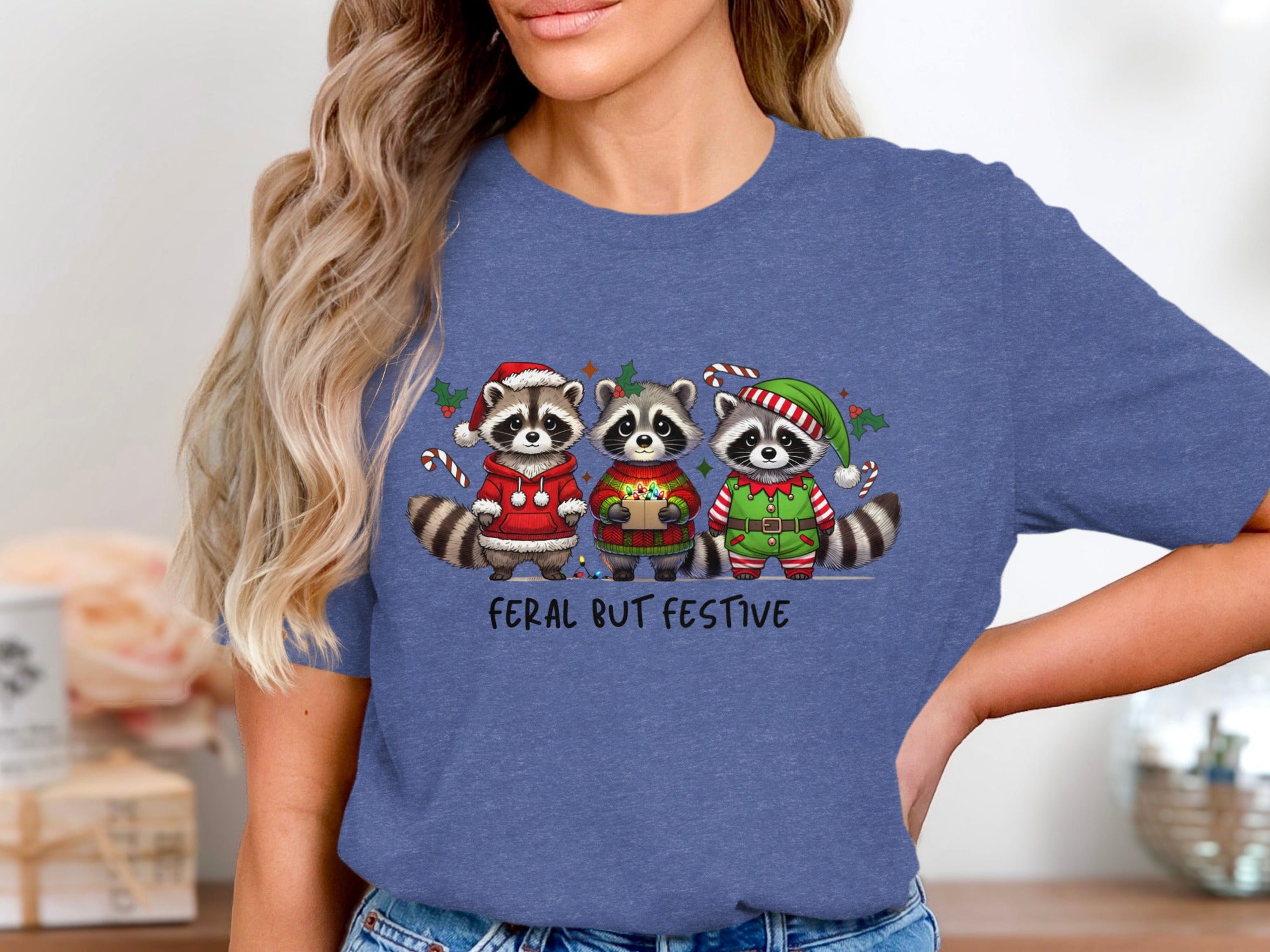 Three raccoons in Christmas attire with text "FERAL BUT FESTIVE".