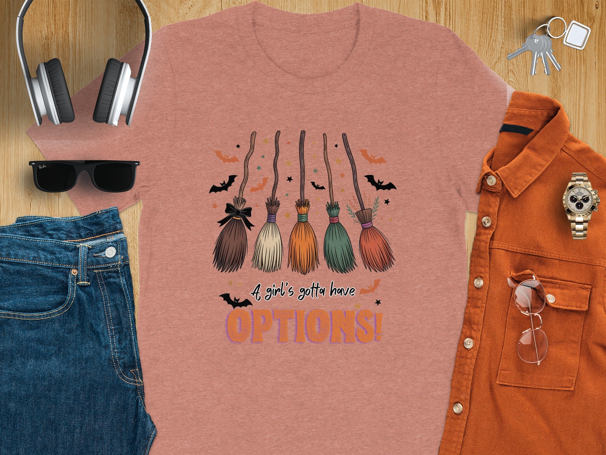 T-shirt with a graphic of five witch brooms and the text "A girl's gotta have OPTIONS!".