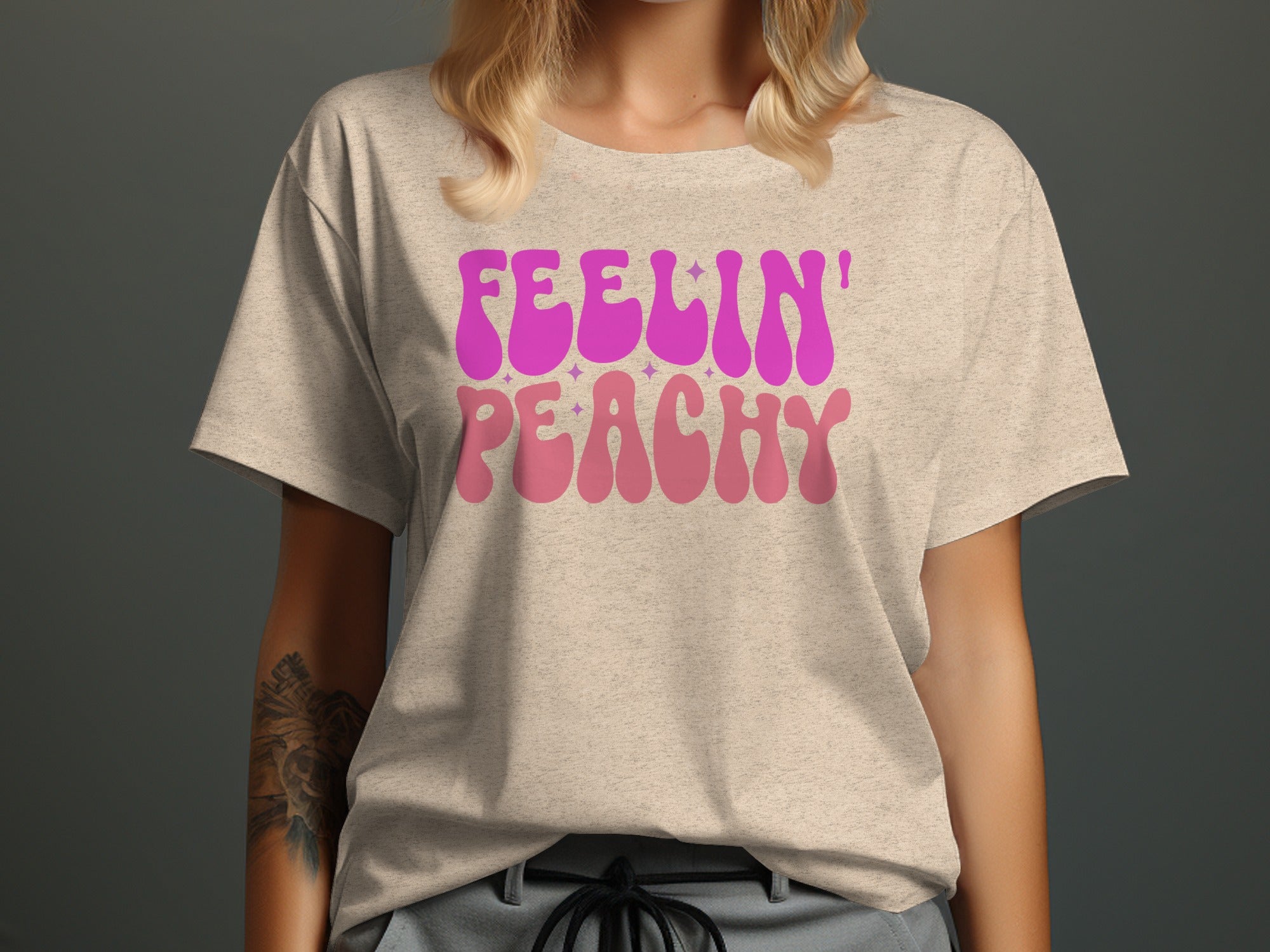 Beige t-shirt with "Feelin' Peachy" in pink and lighter pink groovy font.