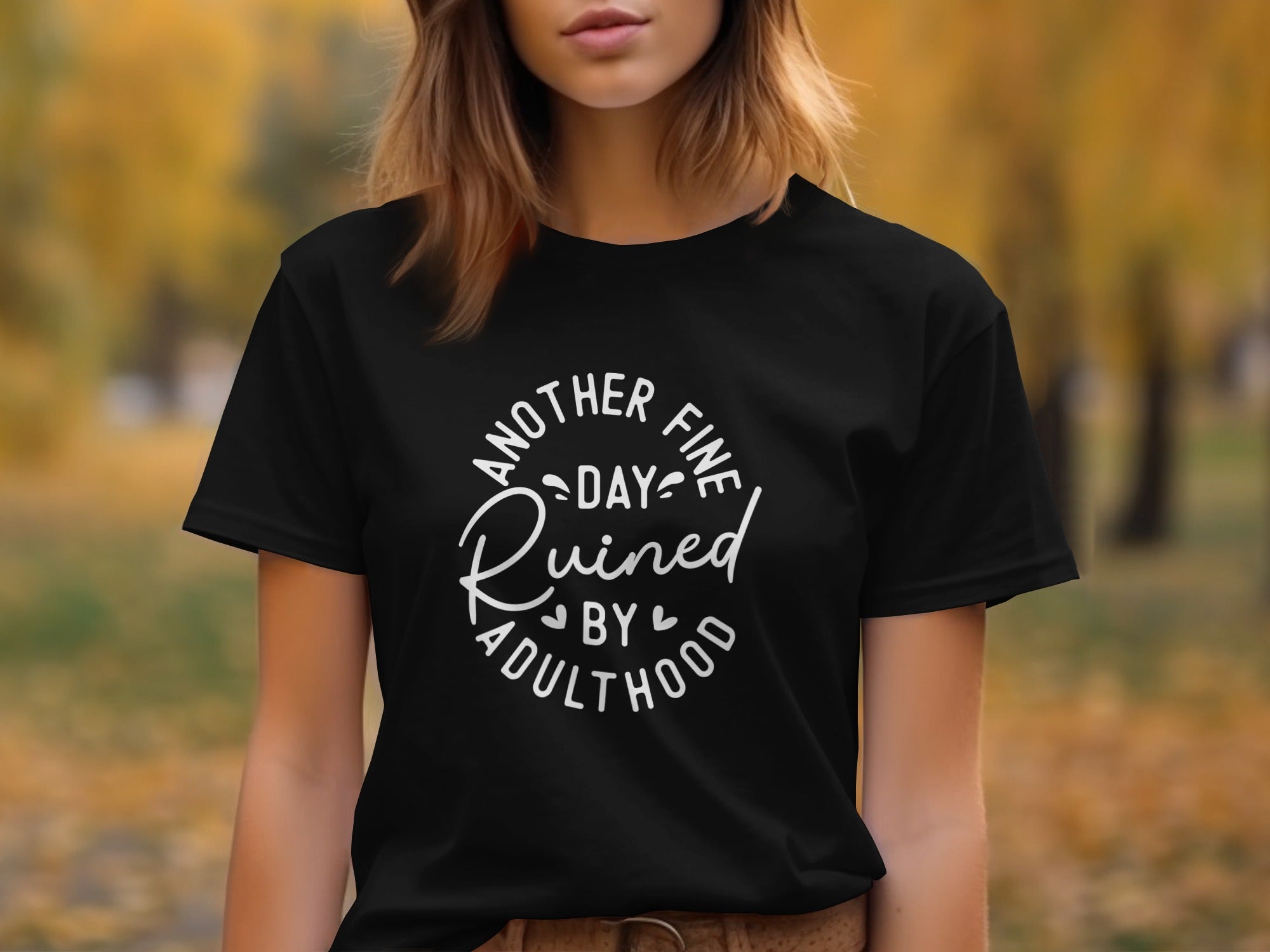 Black t-shirt with white text reading "Another fine day ruined by adulthood"