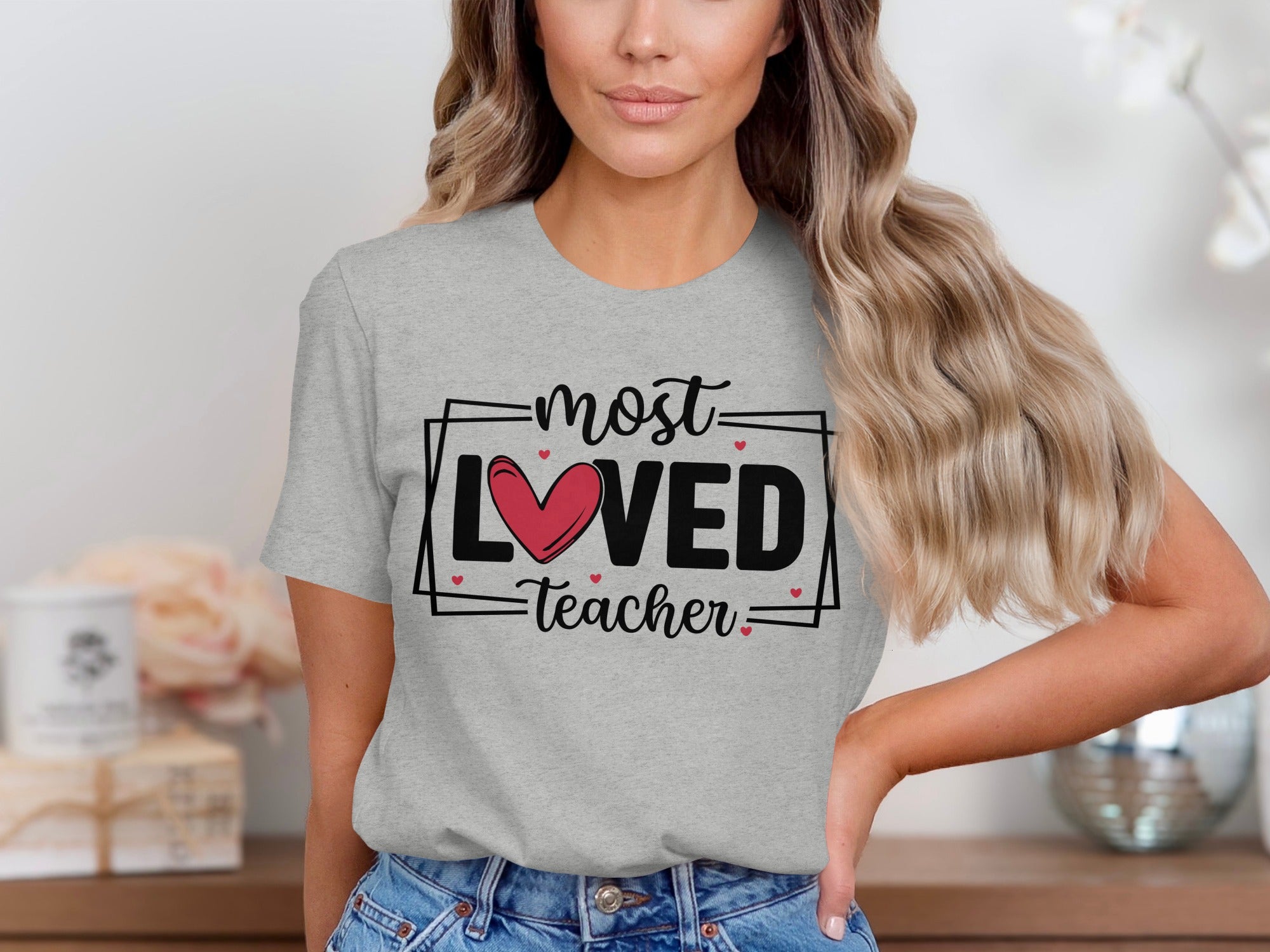 Grey t-shirt with "most LOVED teacher" text and heart graphic.