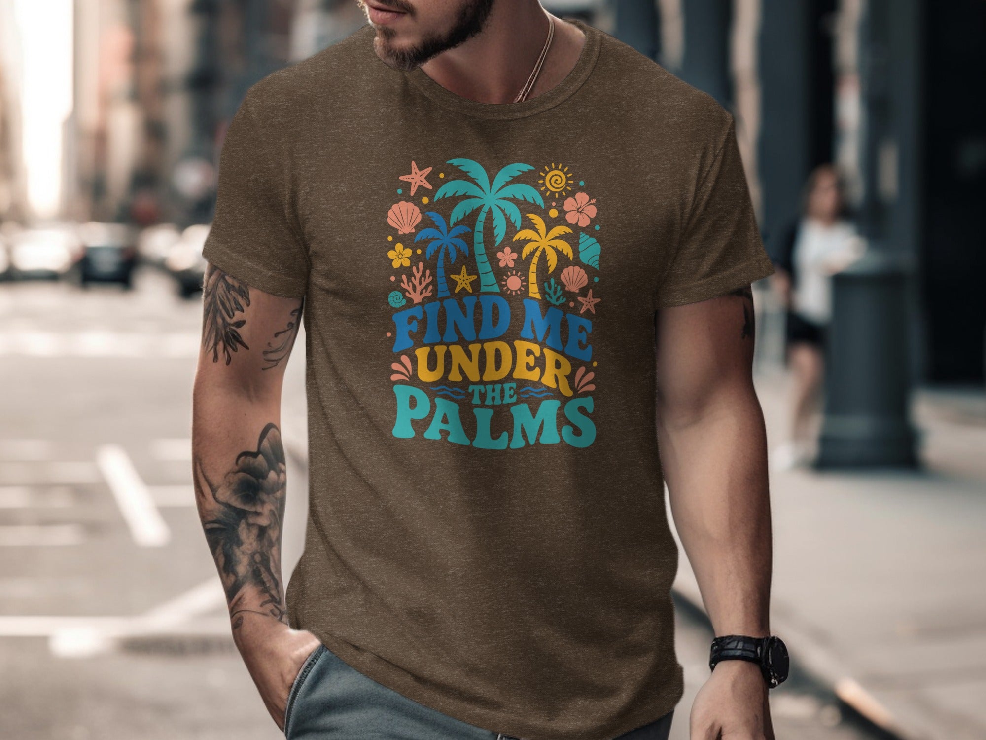 Brown t-shirt with colorful "Find Me Under The Palms" text and tropical graphics.