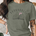 Green t-shirt with "BOOKAHOLIC" text and open book graphic with flowers.