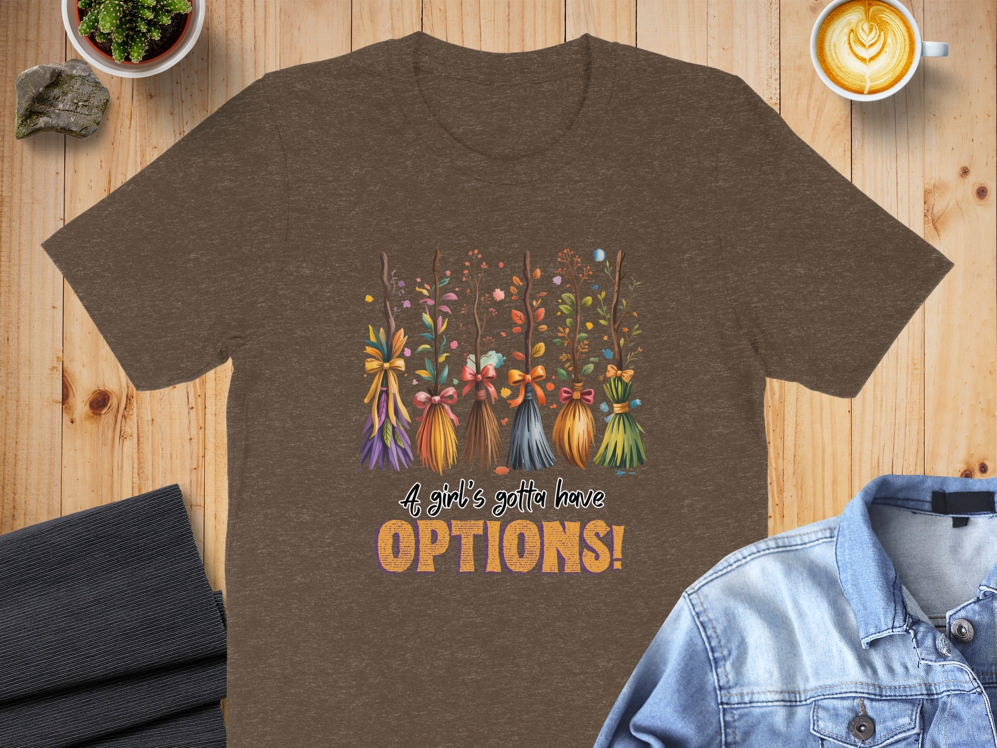 Brown t-shirt with cartoon brooms and text "A girl's gotta have OPTIONS!".