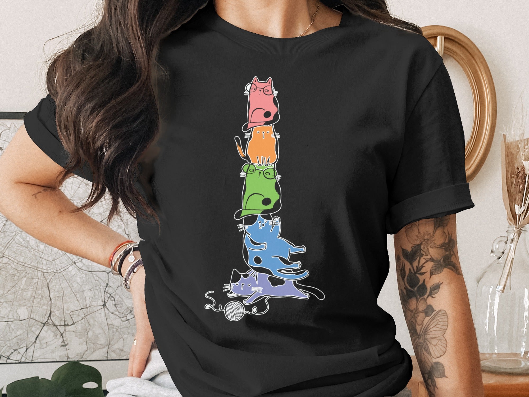 Stack of colorful cartoon cats with glasses and a ball of yarn.