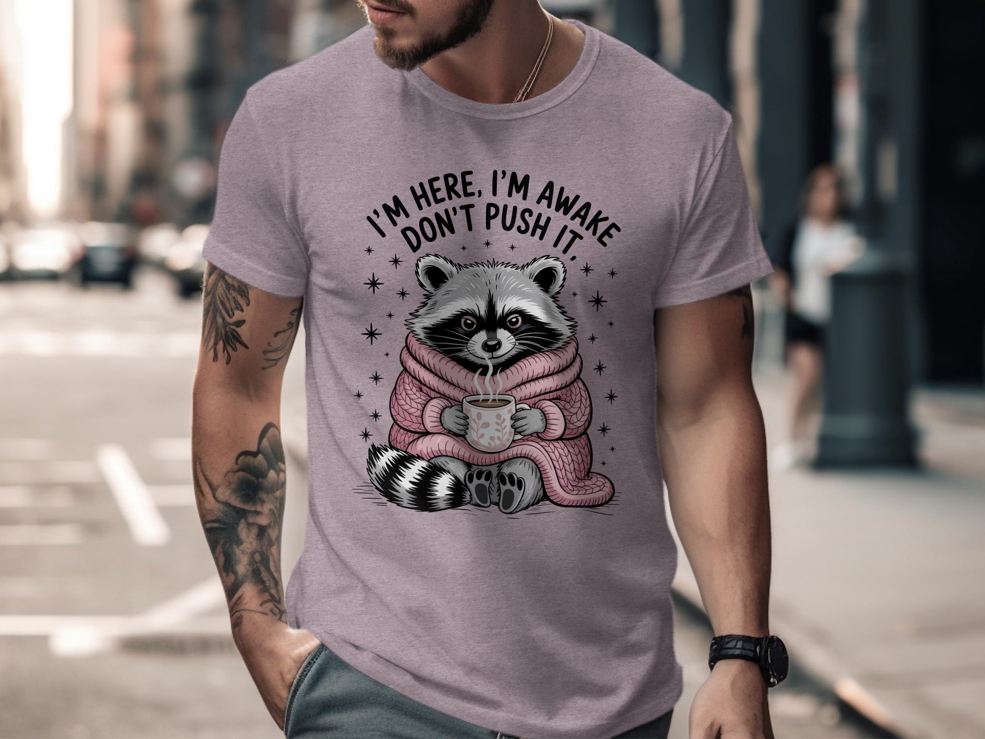 Raccoon in pink sweater holding coffee mug with text "I'm here, I'm awake, don't push it."