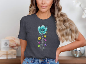 Dark gray t-shirt with a turquoise flower and colorful wildflowers, spelling "mama".