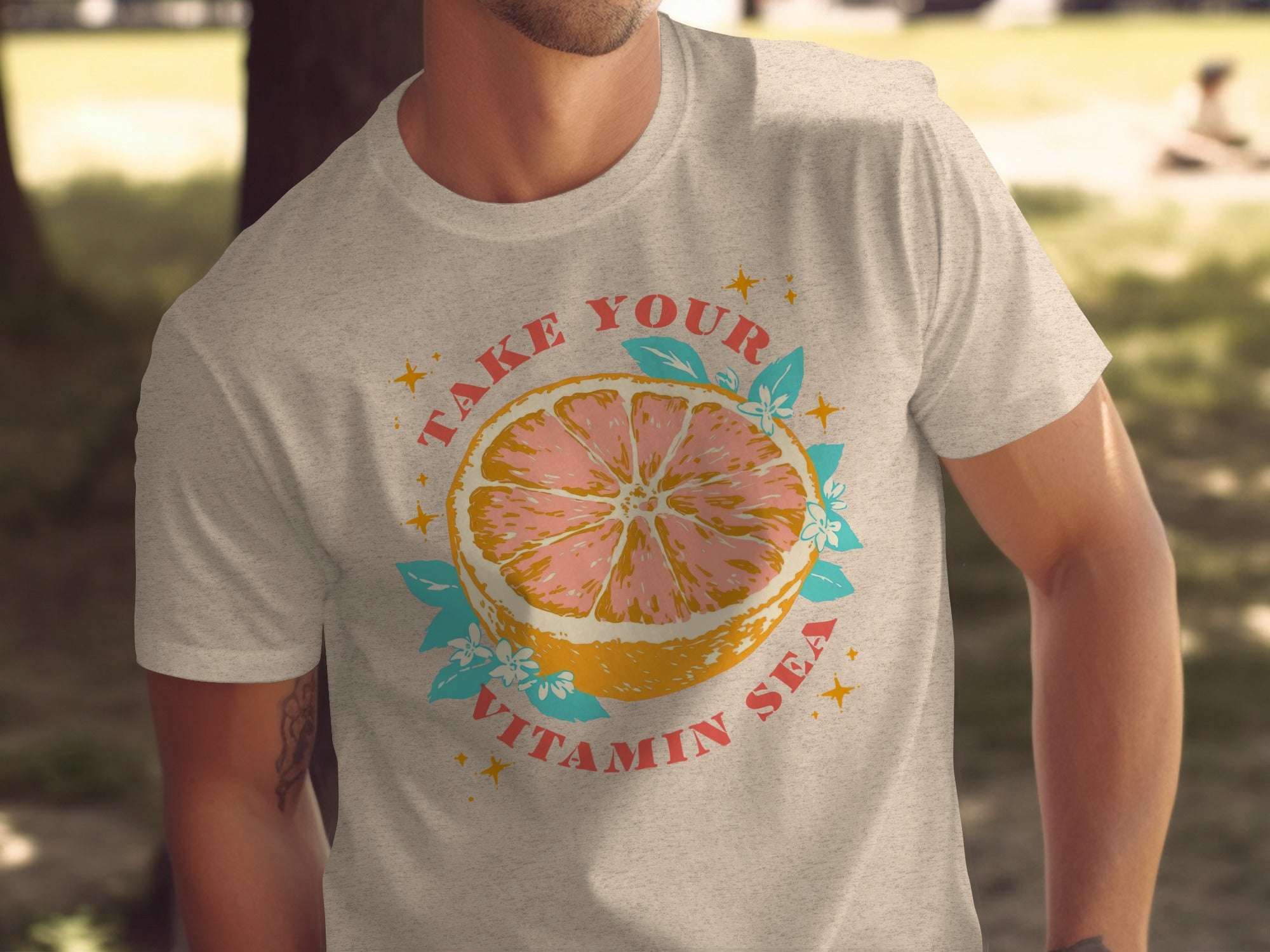 Light gray t-shirt with graphic of grapefruit slice and text "TAKE YOUR VITAMIN SEA."