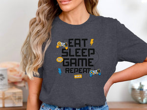 Dark gray t-shirt withEat Sleep Game Repeat, controllers, and play button graphic.