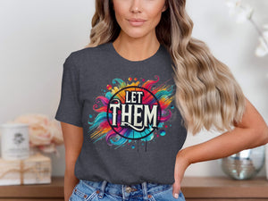 A person wearing a dark grey t-shirt featuring a colorful graphic design with the text Let Them.
