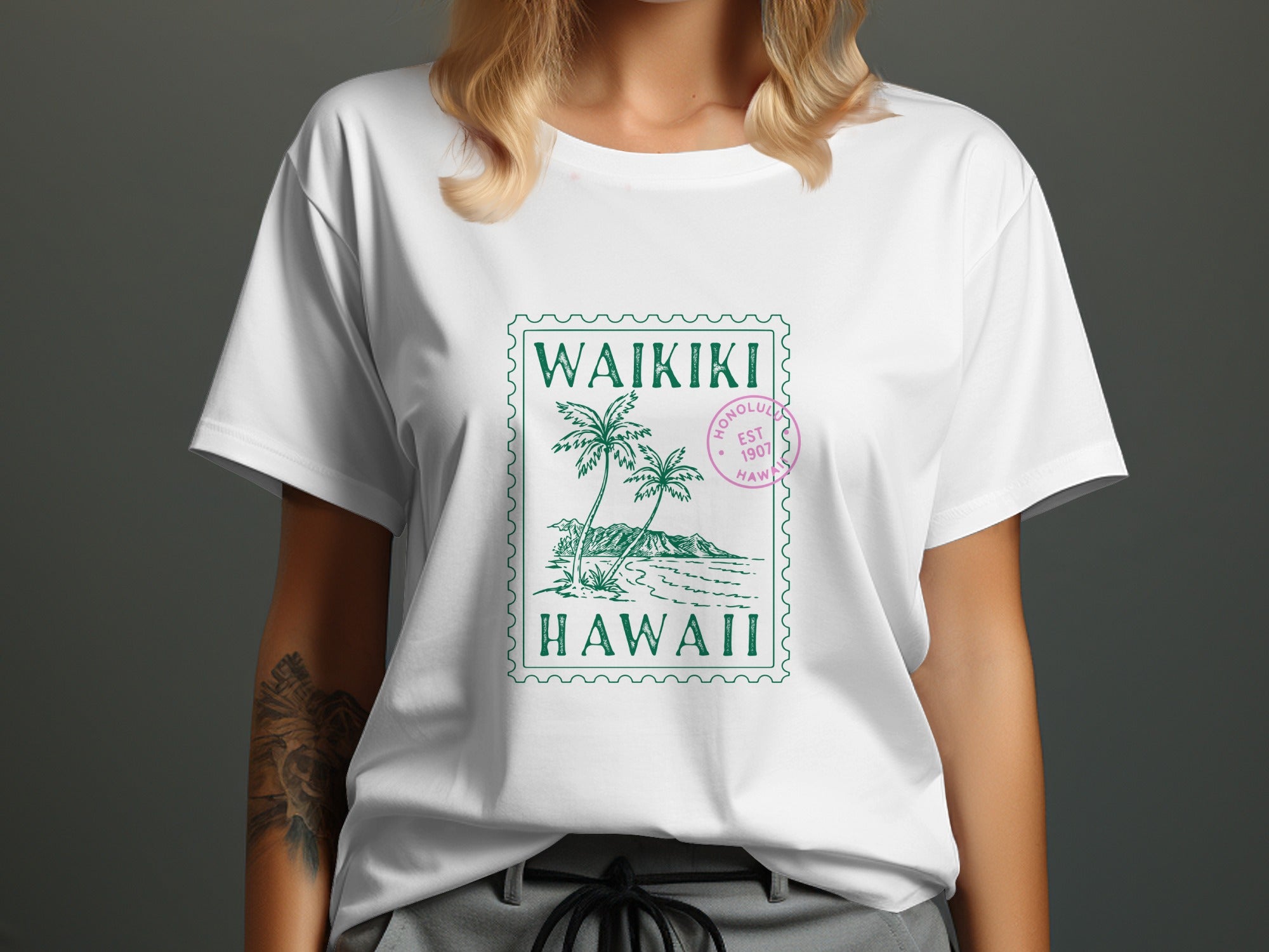 White t-shirt with green Waikiki Hawaii stamp graphic.