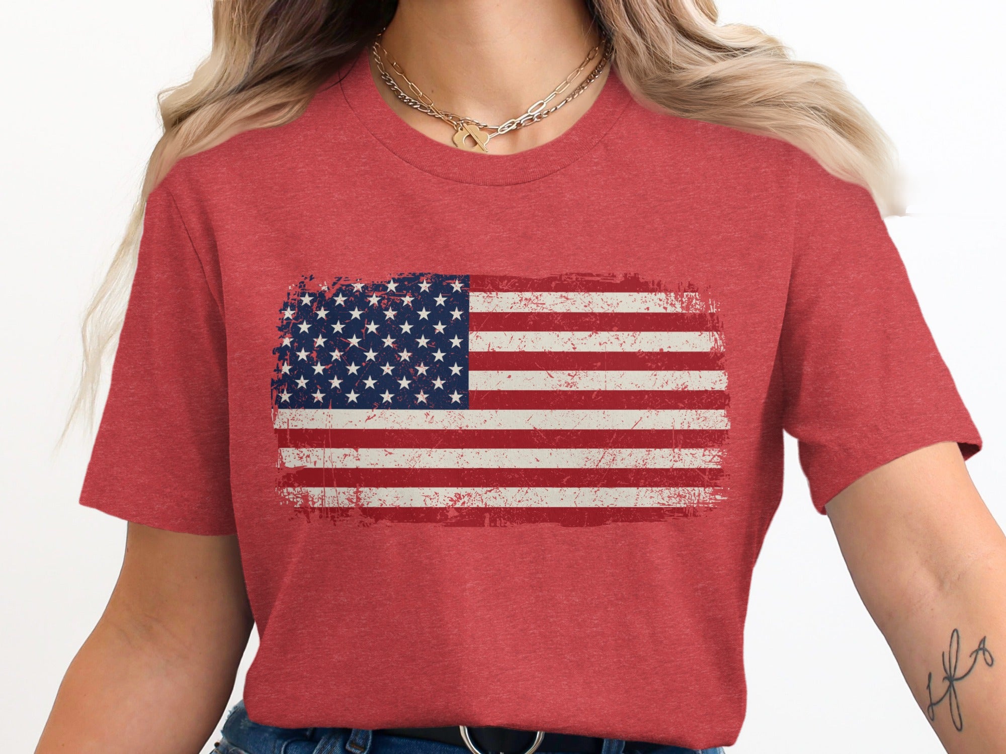 Distressed American flag graphic on a red t-shirt worn by a woman.
