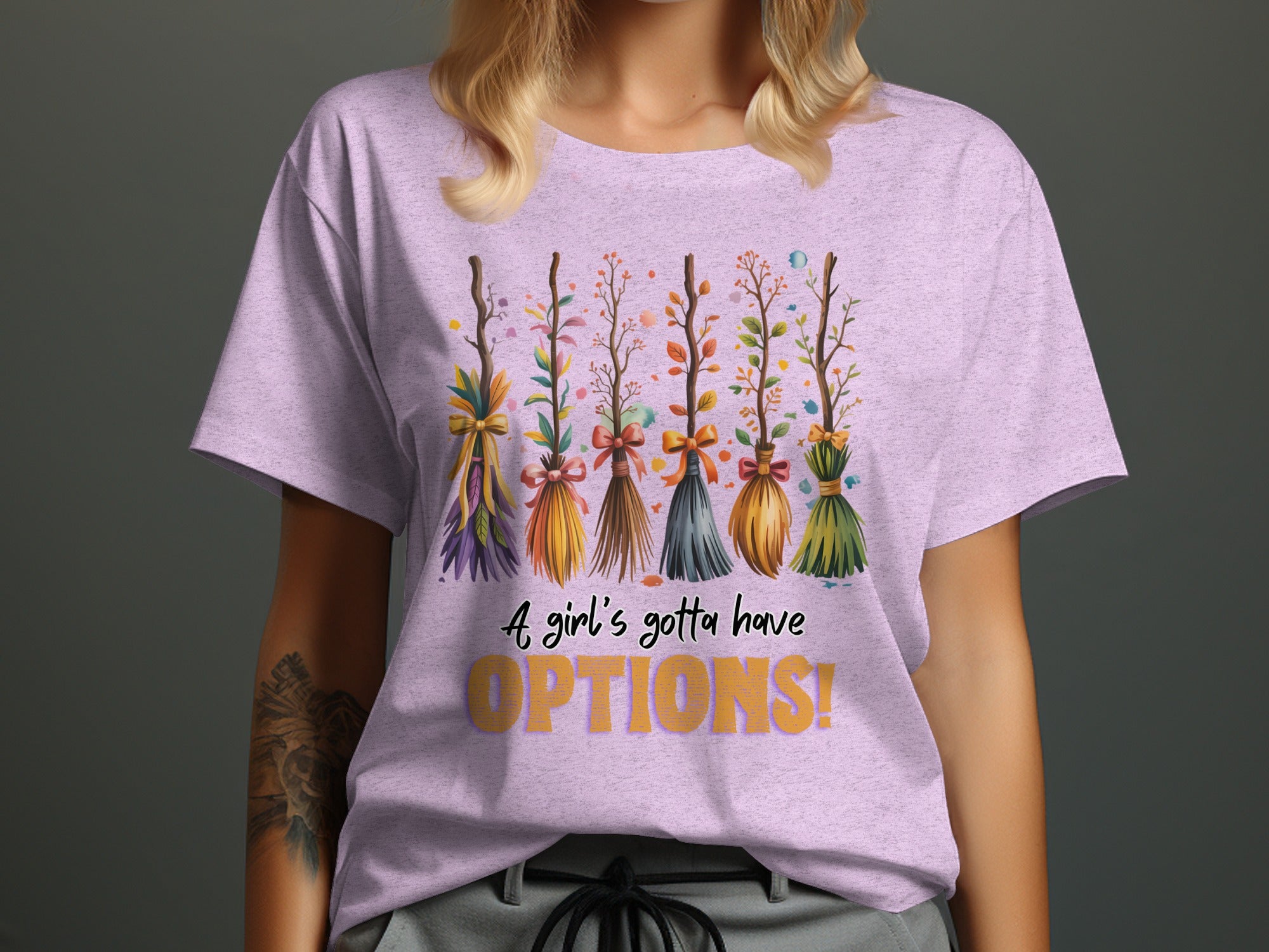 Lavender t-shirt with whimsical brooms and text "A girl's gotta have OPTIONS!"