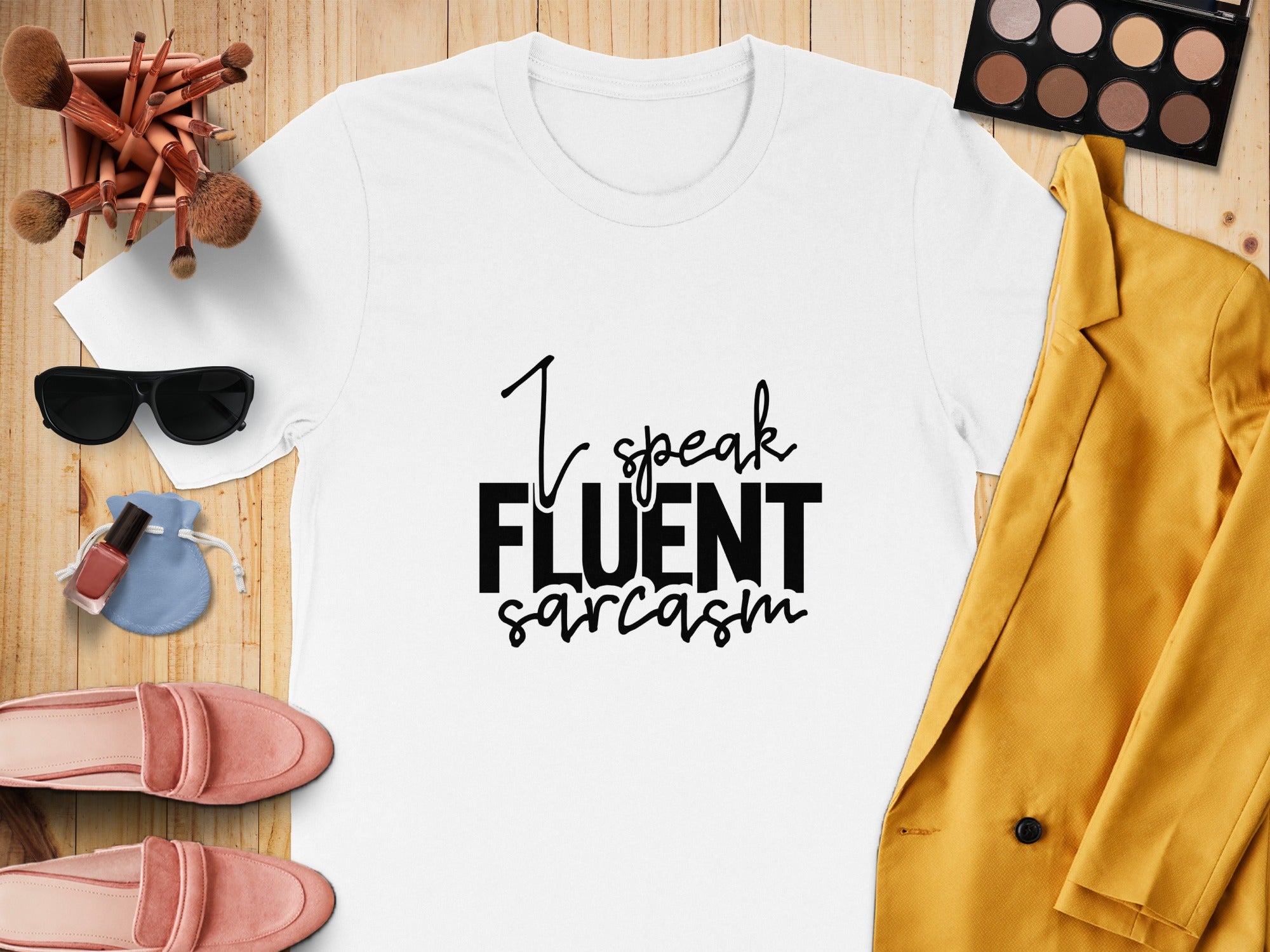 White t-shirt with "I speak FLUENT sarcasm" text, styled with makeup and clothing items.