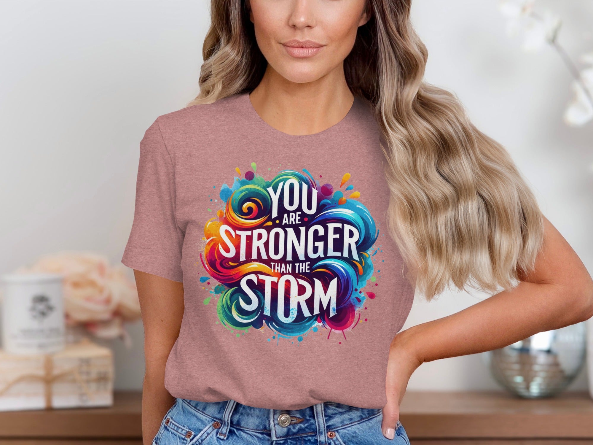 Rose t-shirt with colorful graphic reading "You are stronger than the storm."