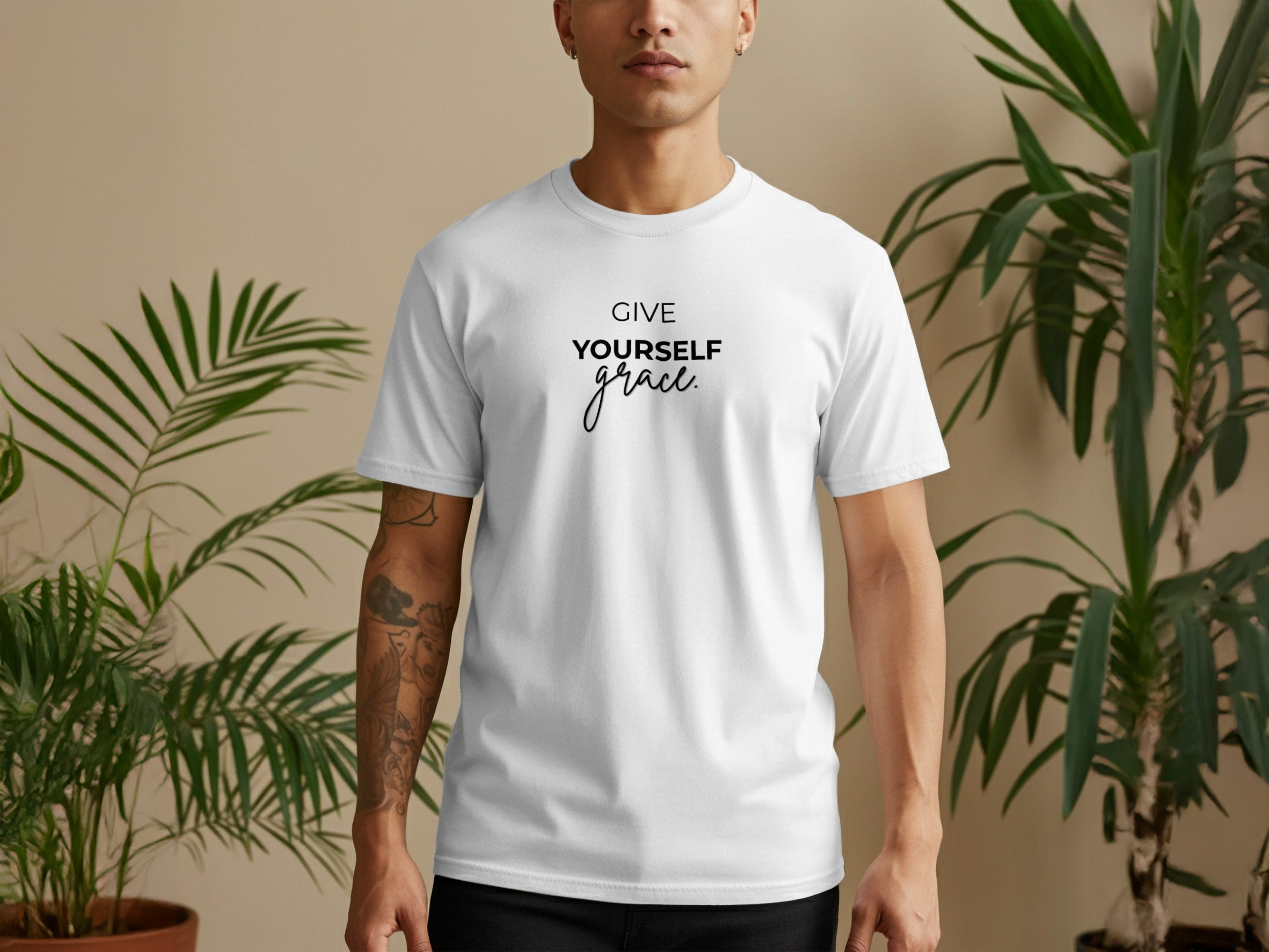 White t-shirt with "GIVE YOURSELF grace" text, worn by a person.