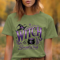 Green t-shirt with "WITCH Social Club" text, witch hat, and cauldron graphic.