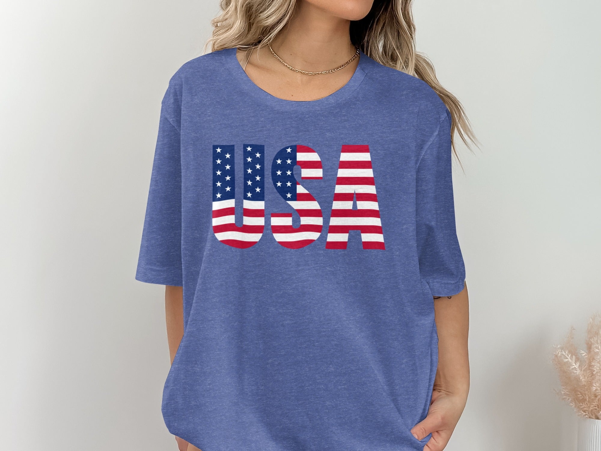 Blue t-shirt with "USA" printed in American flag design.