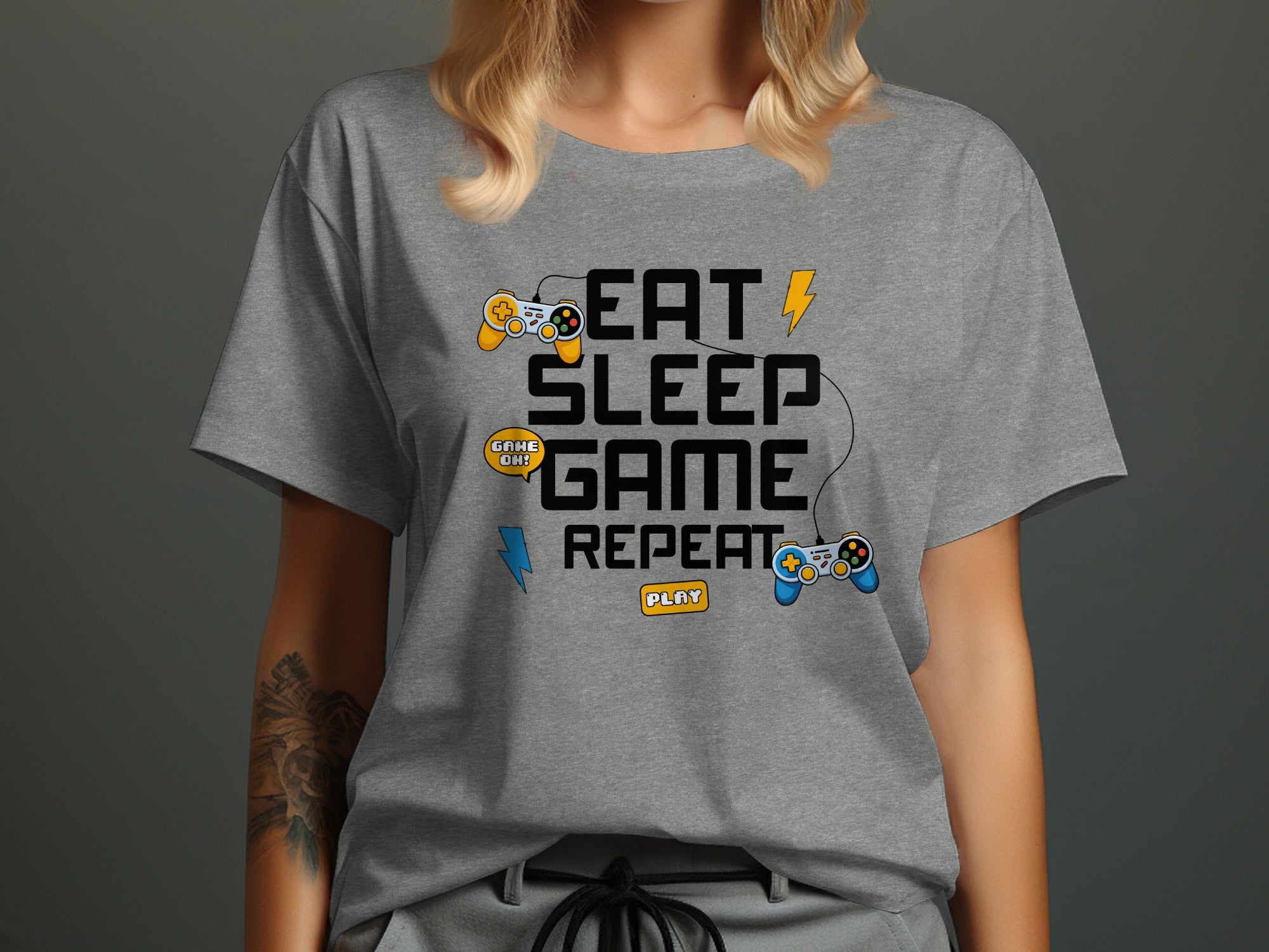 Grey t-shirt with "Eat Sleep Game Repeat" and gaming controllers graphic.