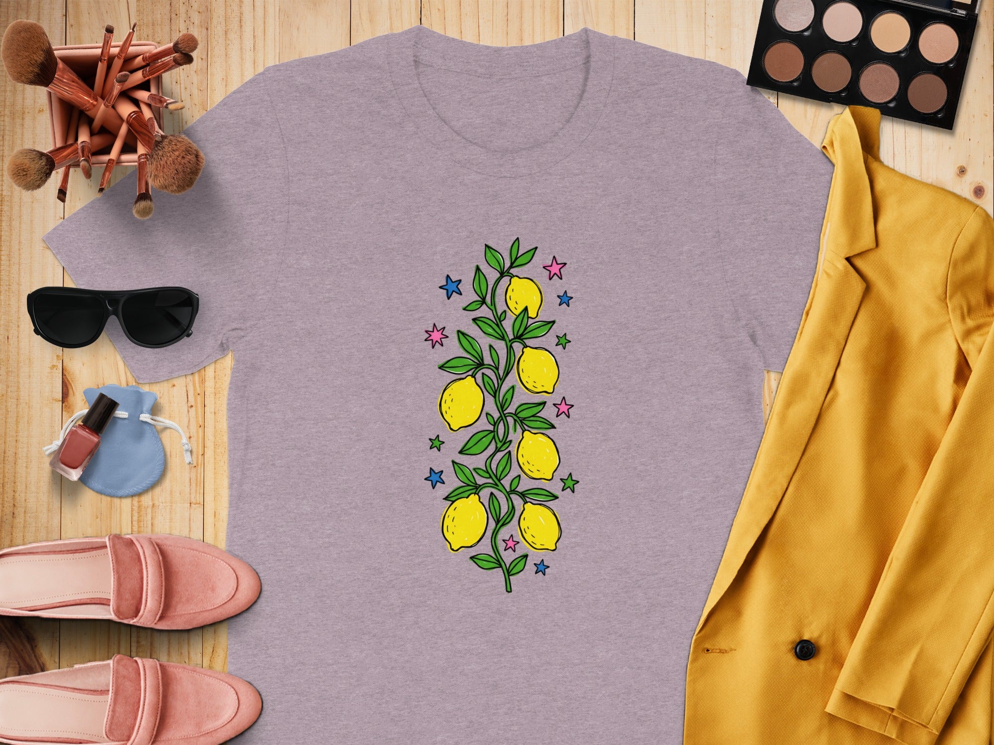 Lavender t-shirt with a lemon branch graphic, surrounded by fashion items.