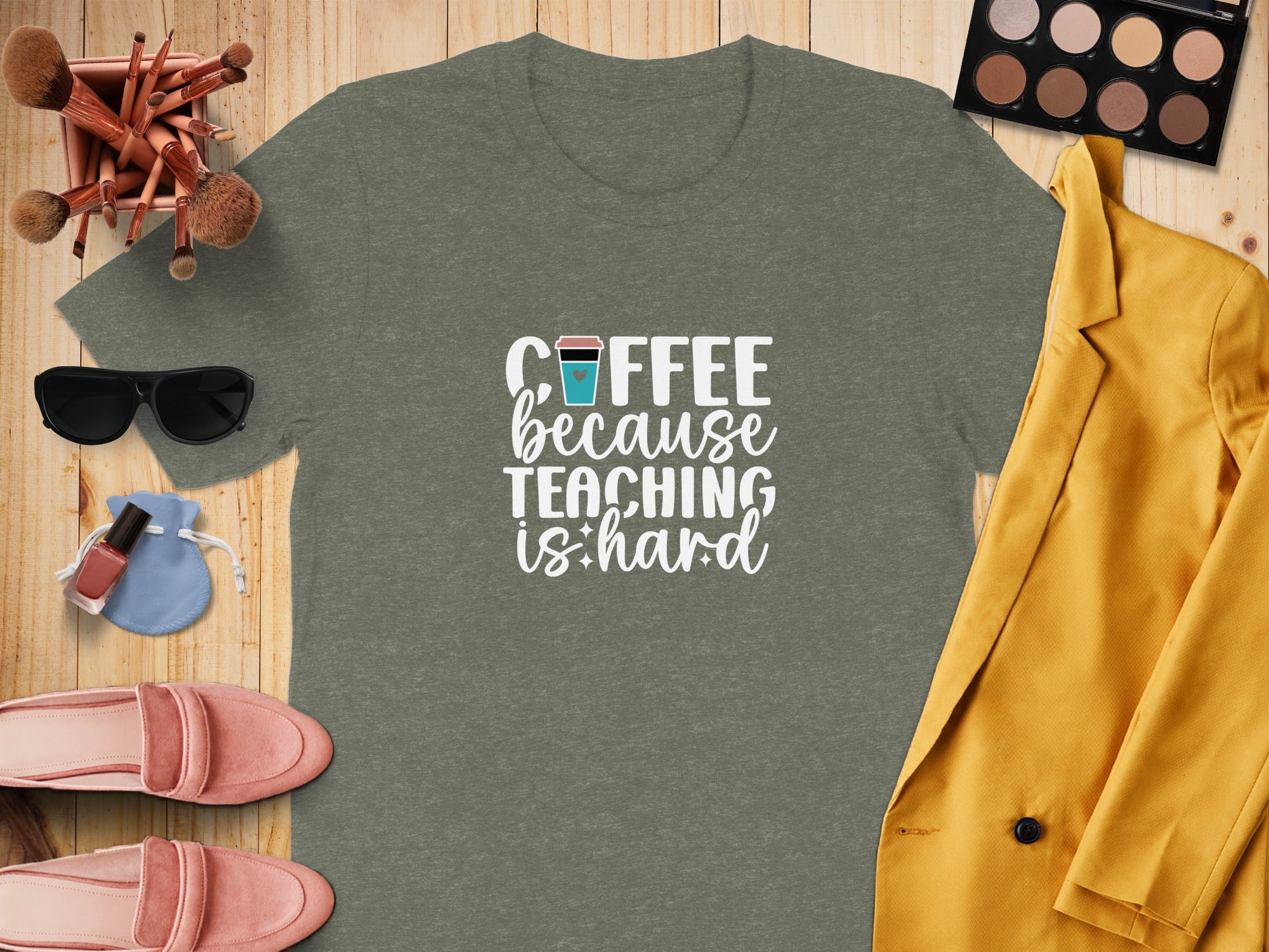 T-shirt with "Coffee because teaching is hard" text, surrounded by makeup brushes, sunglasses, nail polish and flats.