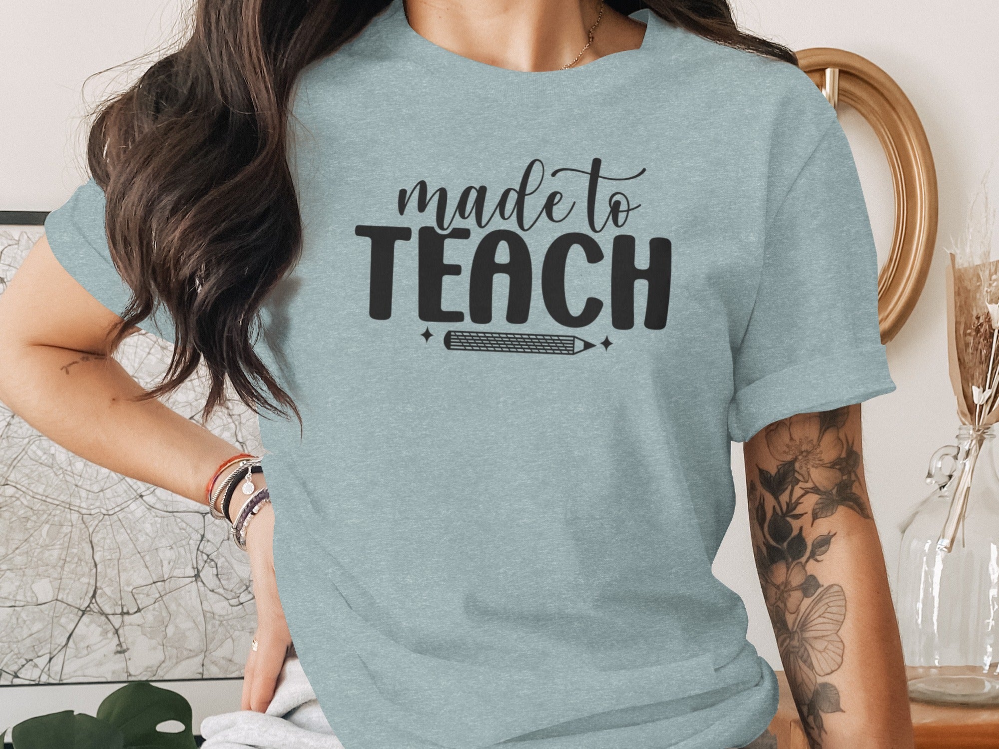 Light blue t-shirt with "made to TEACH" text and a pencil graphic.